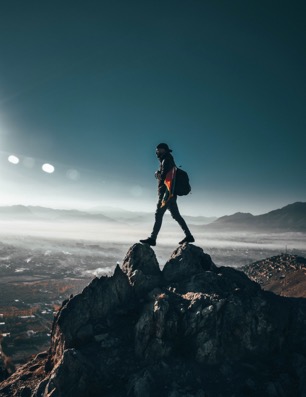 A person standing in front of a mountain Description automatically generated